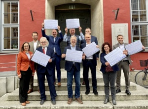 Mitglieder des Nachhaltigkeitsbündnisses präsentieren unterzeichnete Deklaration auf der Rathaustreppe - © Foto: Pressestelle UHGW Mitglieder des Nachhaltigkeitsbündnisses präsentieren unterzeichnete Deklaration auf der Rathaustreppe